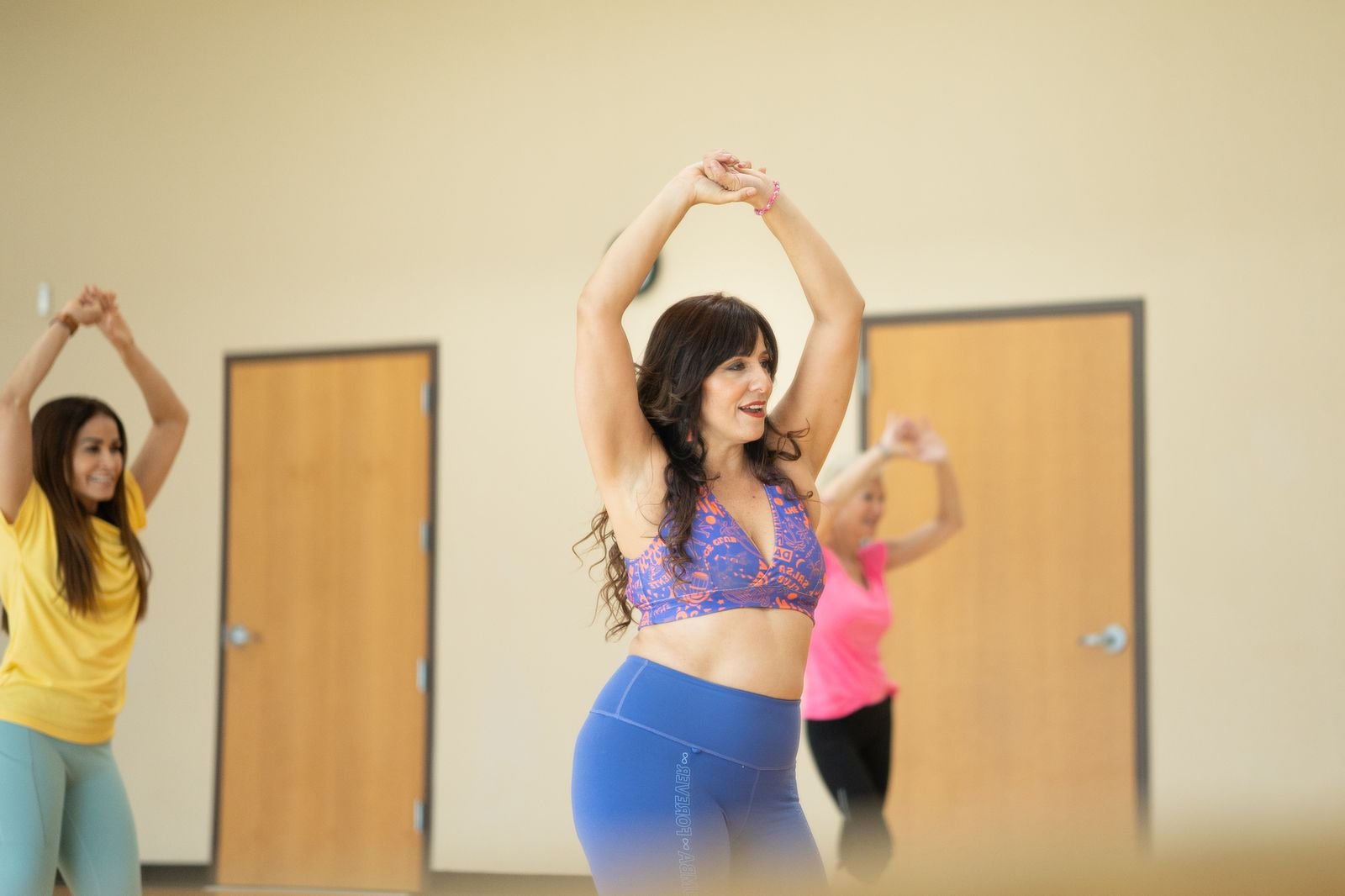 Francesca Vegas bailando zumba con los brazos en alto